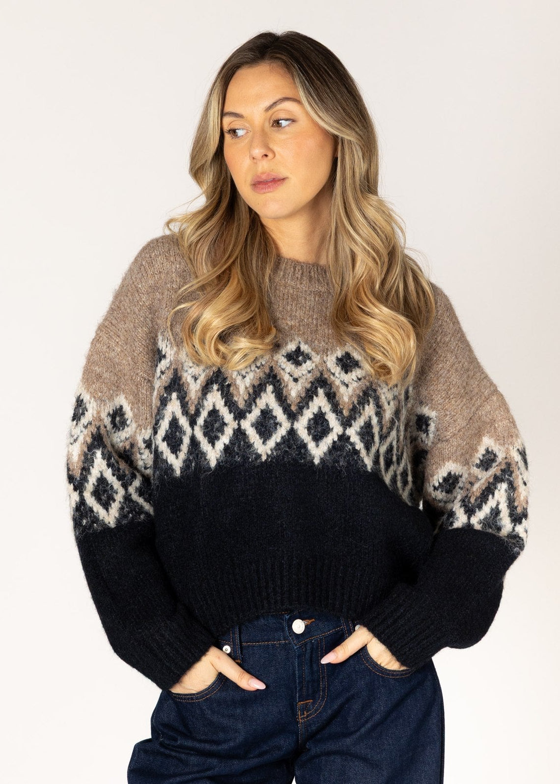 Woman wearing a patterned sweater with a plain background